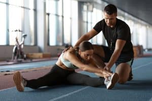 Jovem a treinar acompanhada de um fisioterapeuta após um lesão.